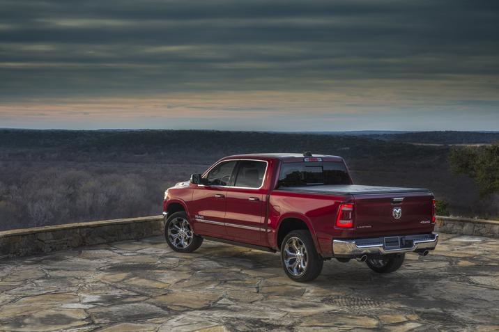 RAM 1500 Limited 2020, design rouge, face à un paysage de forêt sous un ciel nuageux verdâtre