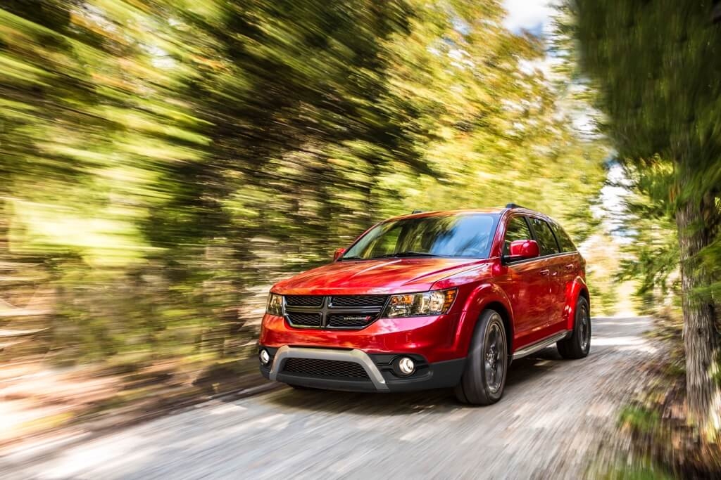 Vue 3/4 avant du VUS Dodge Journey 2018 roulant sur un chemin en nature.