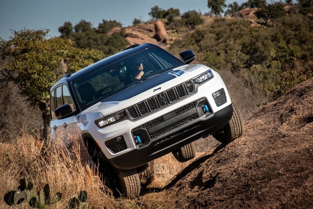 Jeep Grand Cherokee 4xe Trailhawk montant une pente abrupte en sentier tout-terrain.