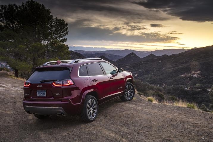 Jeep Cherokee Overland 2020 situé sur une colline avec le couché du soleil, avec les montagnes au loin
