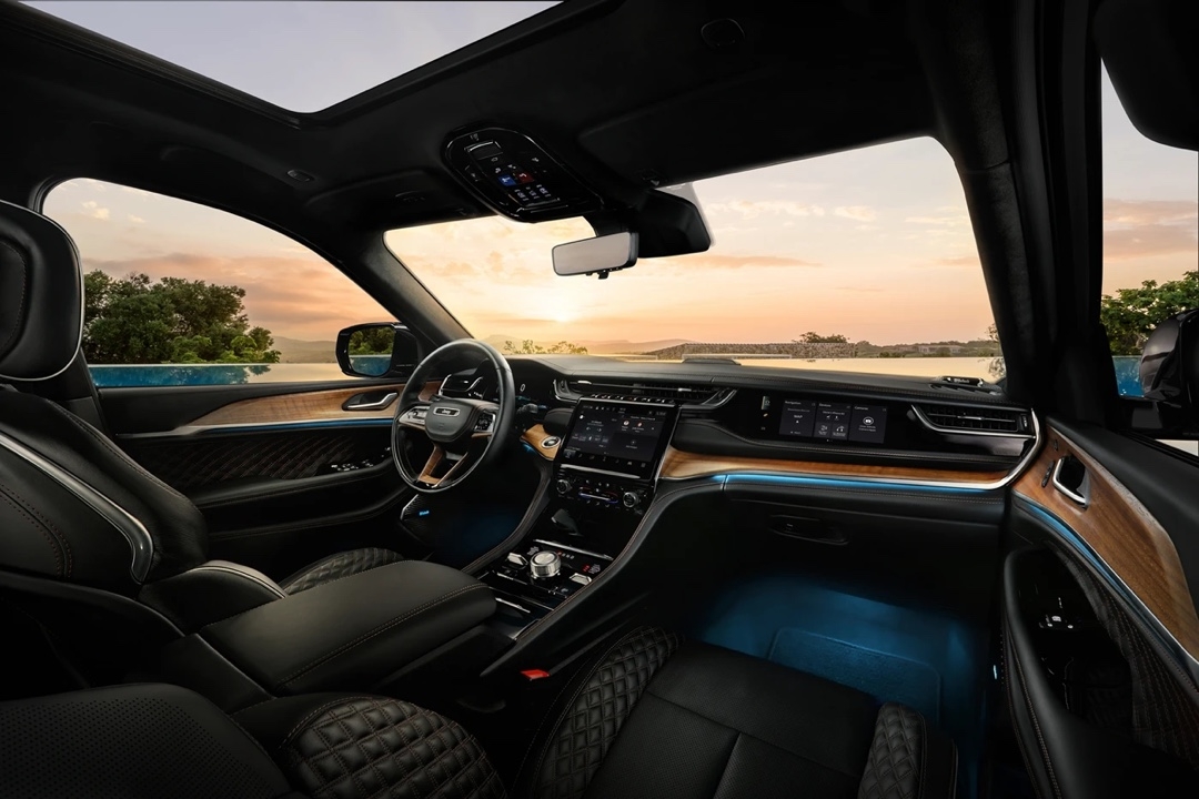 Habitacle luxueux du Jeep Grand Cherokee 4xe 2025 avec éclairage d’ambiance bleu.