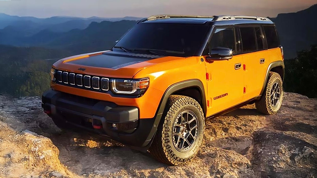 Jeep Recon VEB 2026 orange stationné au sommet d’un rocher avec vue sur les montagnes. Vue latérale avant.